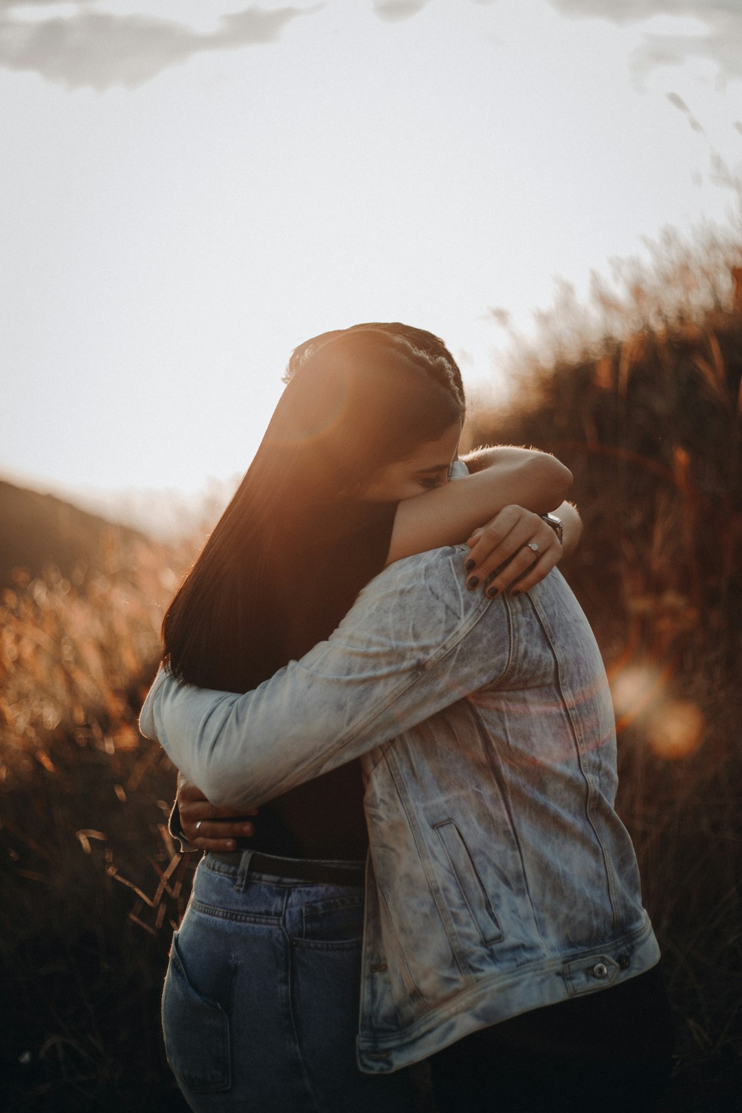 woman-in-black-long-sleeve-shirt-and-blue-denim-jeans-covering-her-face-with-her-hand-zdfbpjbmzum